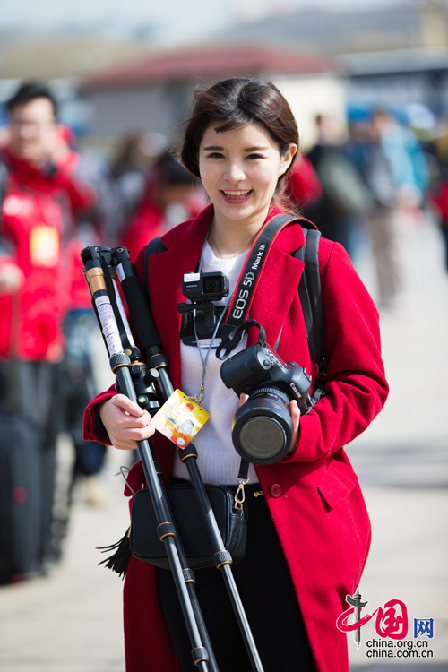 2016年兩會，人民大會大堂前，一位笑容燦爛的紅衣女記者正步入大會堂。中國網(wǎng) 鄭亮 攝