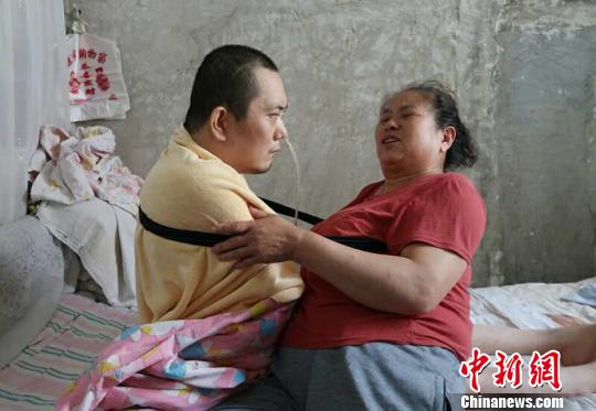 身體日漸衰老的梁青蘭每次幫兒子翻身、坐立，全身的衣物都要濕透一次?！∩忻鱾b 攝