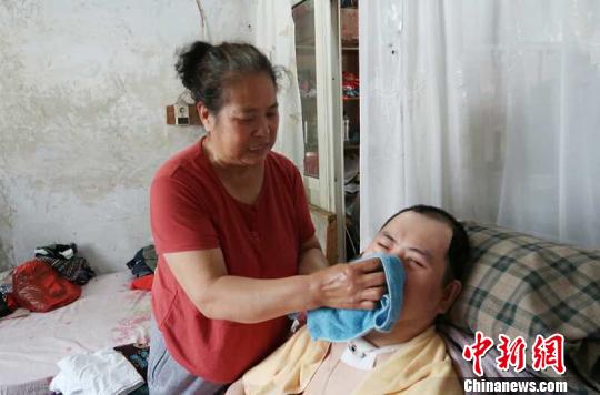 每次喂完食物后，梁青蘭都要仔細(xì)地幫兒子清理干凈?！∩忻鱾b 攝