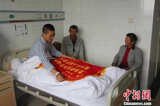 被救的李忠起、張總鳳夫婦看望受傷后的李運(yùn)飛?！⊥粲?攝
