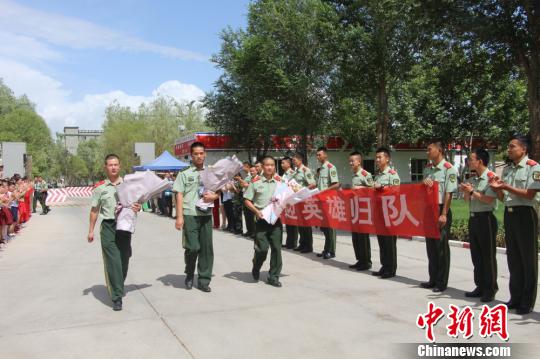 部隊(duì)官兵們迎接出院歸來的李運(yùn)飛(中)和其他消防戰(zhàn)士?！⊥粲?攝