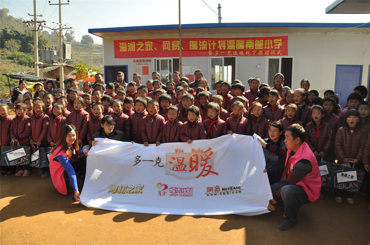 2014年11月20日，“多一克溫暖”公益團(tuán)隊(duì)來到8.3大地震的重災(zāi)區(qū)——云南省昭通市魯?shù)榭h的南筐小學(xué)。越過崎嶇山路，將一批又一批暖心羽絨服送到了師生們的手中，也將社會(huì)的關(guān)懷和愛意傳遞給了這些可愛的人。