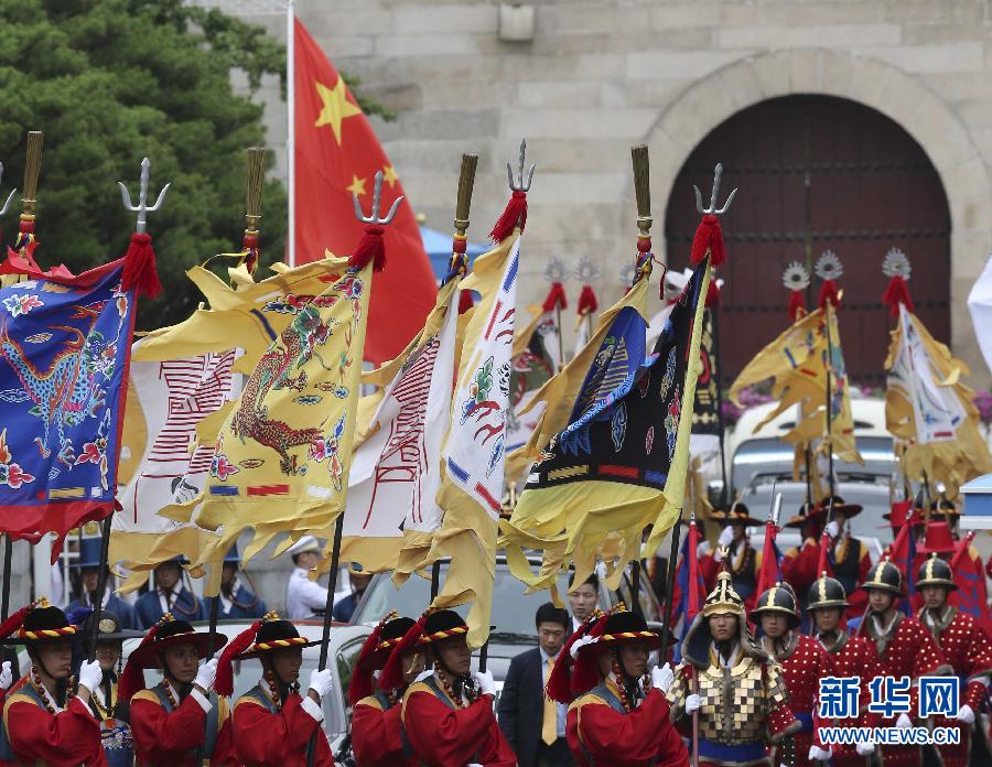7月3日，韓國總統(tǒng)樸槿惠在青瓦臺總統(tǒng)府舉行隆重儀式，歡迎中國國家主席習(xí)近平對韓國進(jìn)行國事訪問。這是習(xí)近平的車隊(duì)在身著民族服裝的韓國禮儀隊(duì)伍引導(dǎo)下駛?cè)肭嗤吲_。新華社記者丁林?jǐn)z  