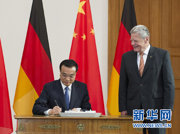 10月10日，國務(wù)院總理李克強在柏林會見德國總統(tǒng)高克。這是李克強總理在高克總統(tǒng)的陪同下在貴賓簿上簽字。 新華社記者 王曄 攝 