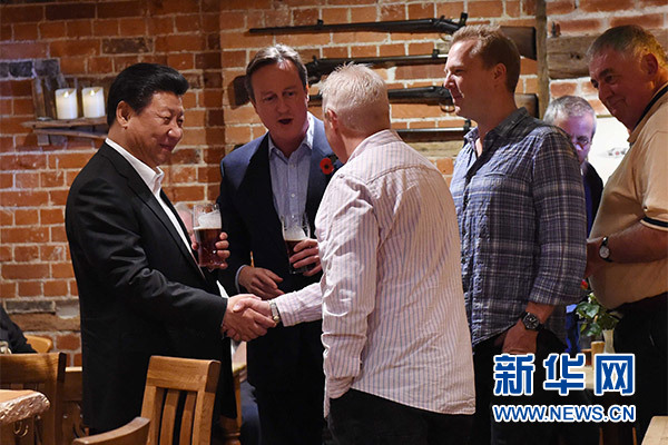 這是習(xí)近平與卡梅倫飲啤酒，并同當(dāng)?shù)孛癖娊徽劇Ｐ氯A社記者 饒愛(ài)民 攝